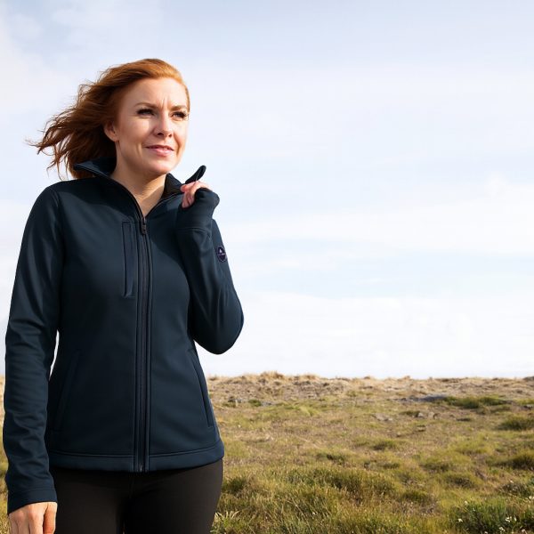 une femme avec veste softshell se promène sur une falaise
